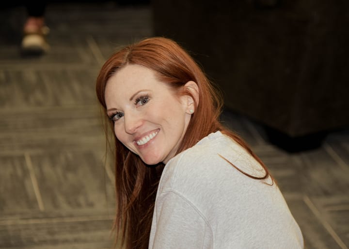 A smiling guest turning toward the camera in the arena