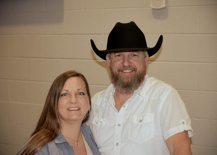 Two guests posing together, one wearing a black cowboy hat