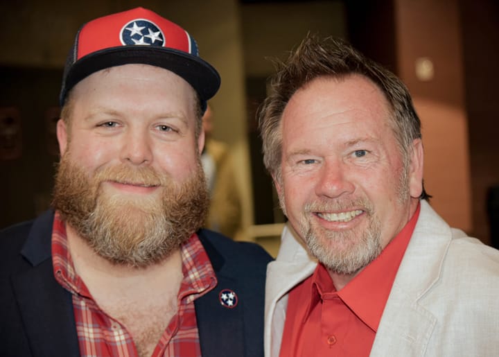 Two guests smiling, one wearing a Tennessee cap