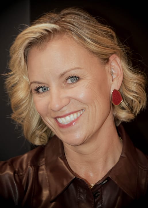 A smiling guest in a brown jacket
