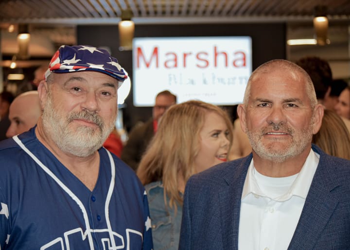 Two guests posing, one wearing a star-patterned cap