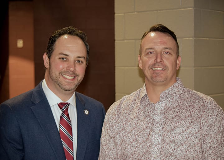 Two guests posing in a blue blazer and patterned shirt