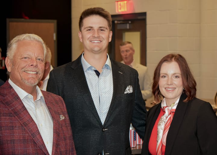 Three guests posing in blazers near the event entrance