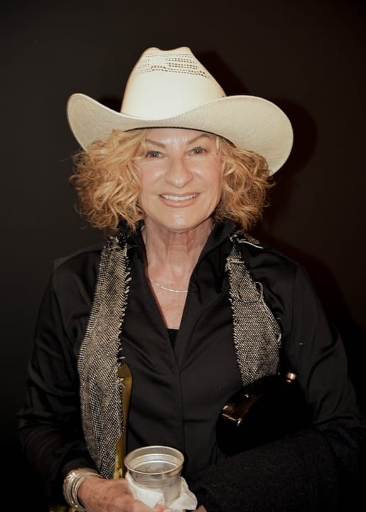 A guest in a white cowboy hat holding a drink