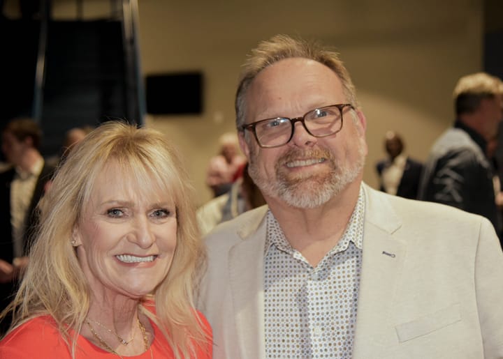 Two guests posing in a red top and light blazer