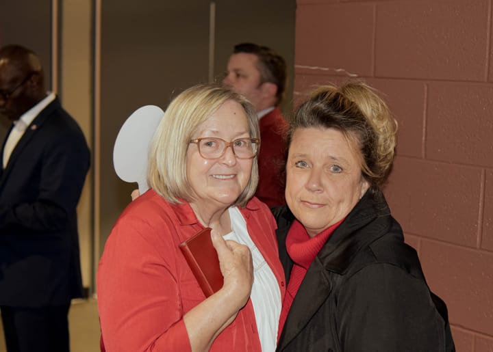 Two guests posing together in red and black jackets
