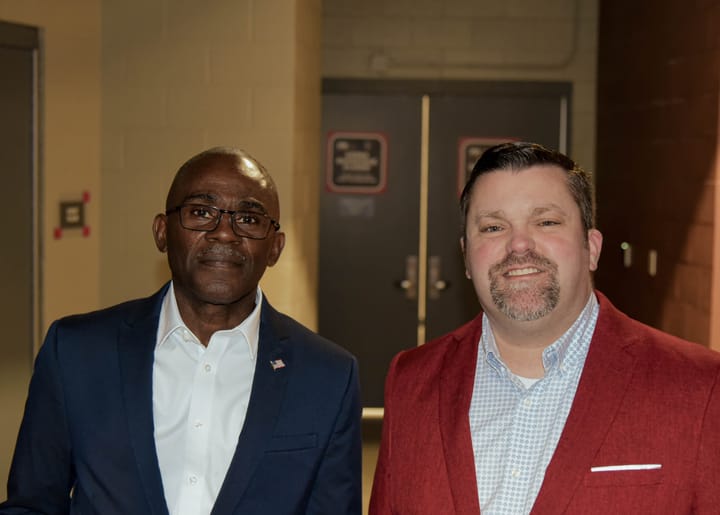 Two guests posing in blue and burgundy blazers