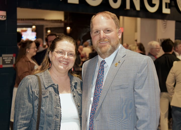 Two guests posing in a denim jacket and gray suit