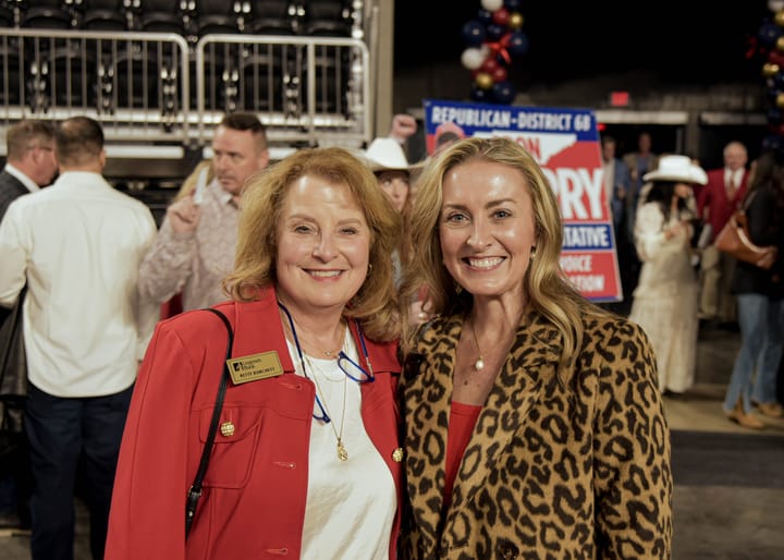 Two smiling guests in red and animal-print jackets