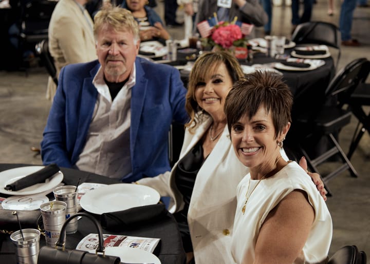 Three guests seated together at a dinner table