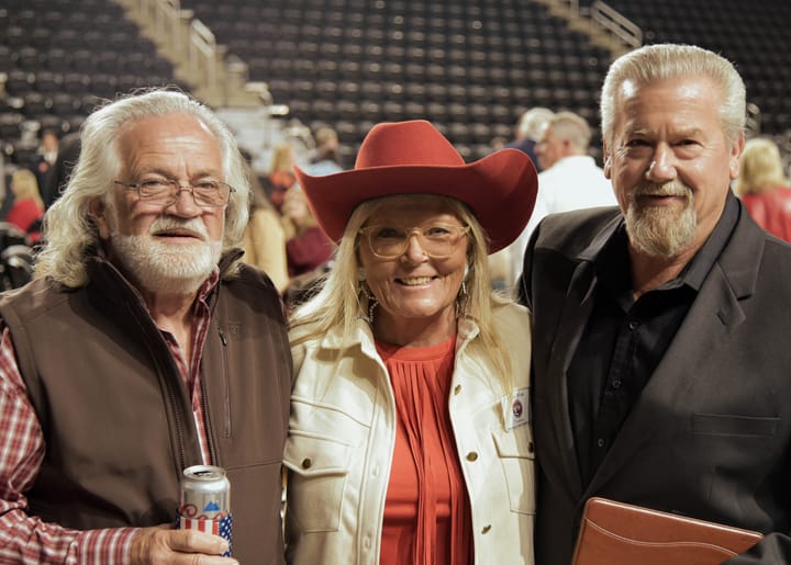 Three guests posing together, with a red cowboy hat in the center