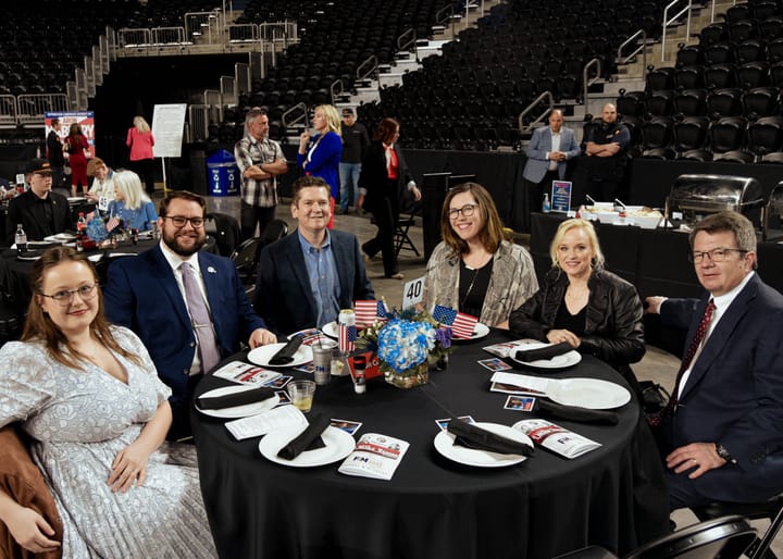 A group of guests posing around a decorated dinner table