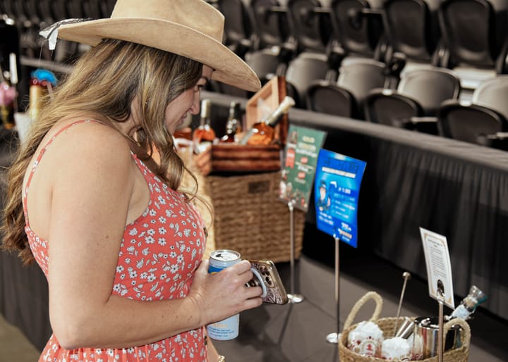 A guest in a tan cowboy hat looking at the auction display