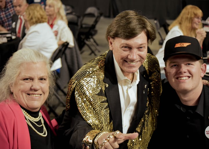 Three guests posing together, with a gold sequined jacket in the center