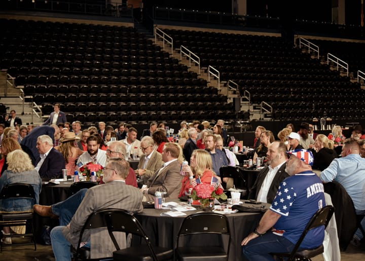 A view across dinner tables with guests facing the stage