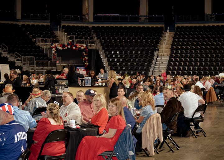 Guests at dinner tables with the serving area behind them