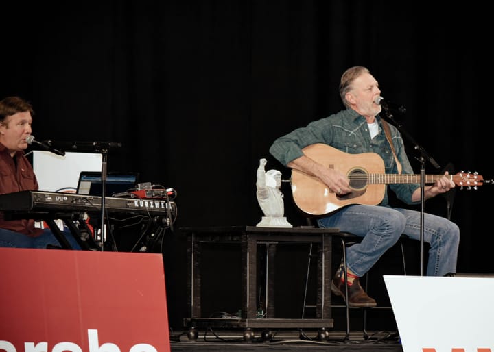 A keyboard player and acoustic guitarist performing together on stage