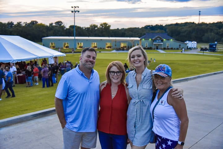 Four guests gathered beside the event tent