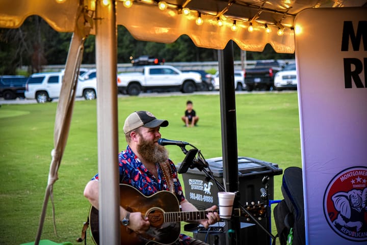 A musician performing beneath the tent