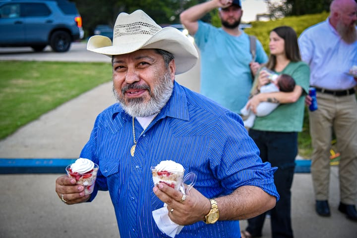A guest in a cowboy hat carrying desserts