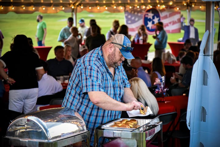 A guest at the food table beneath the tent