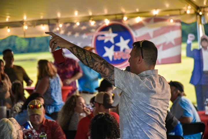 A speaker raising an arm while addressing the gathering