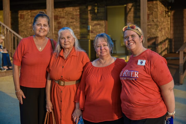 Four guests wearing red near the venue building