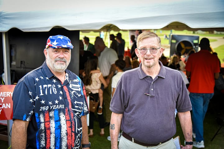 Two guests posing at the entrance to the tent