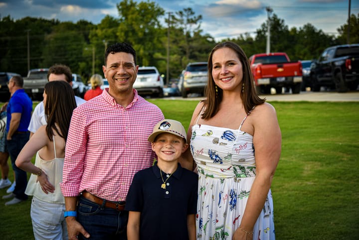 Three guests posing together outdoors
